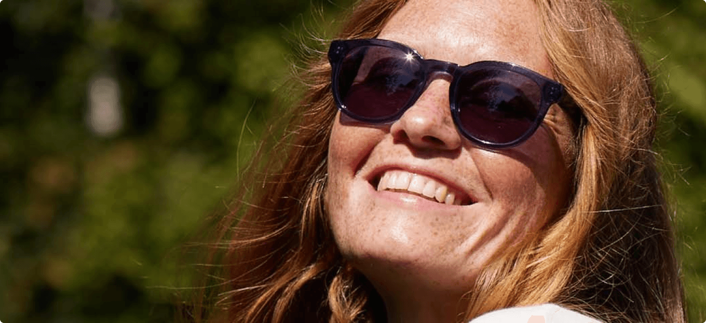 En glad kvinde med solbriller der kan lide de mange karrieremuligheder der er i Specsavers. 