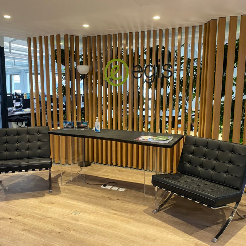 Picture of a waiting room in an EGIS office in Asia. There are two chairs, a table and some wooden planks behind