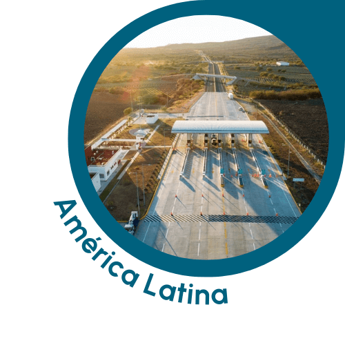 Uma imagem circular com uma borda azul-petróleo que mostra uma praça de pedágio de uma rodovia na América Latina. A imagem apresenta várias pistas da rodovia passando pelas cabines de pedágio, com a infraestrutura ao redor e o terreno aberto se estendendo à distância. A cena é banhada por uma luz solar quente, sugerindo o início da manhã ou o final da tarde. O texto “América Latina” está escrito em azul-petróleo, curvando-se ao longo da borda inferior esquerda do círculo, indicando o contexto latino-americano da cena.