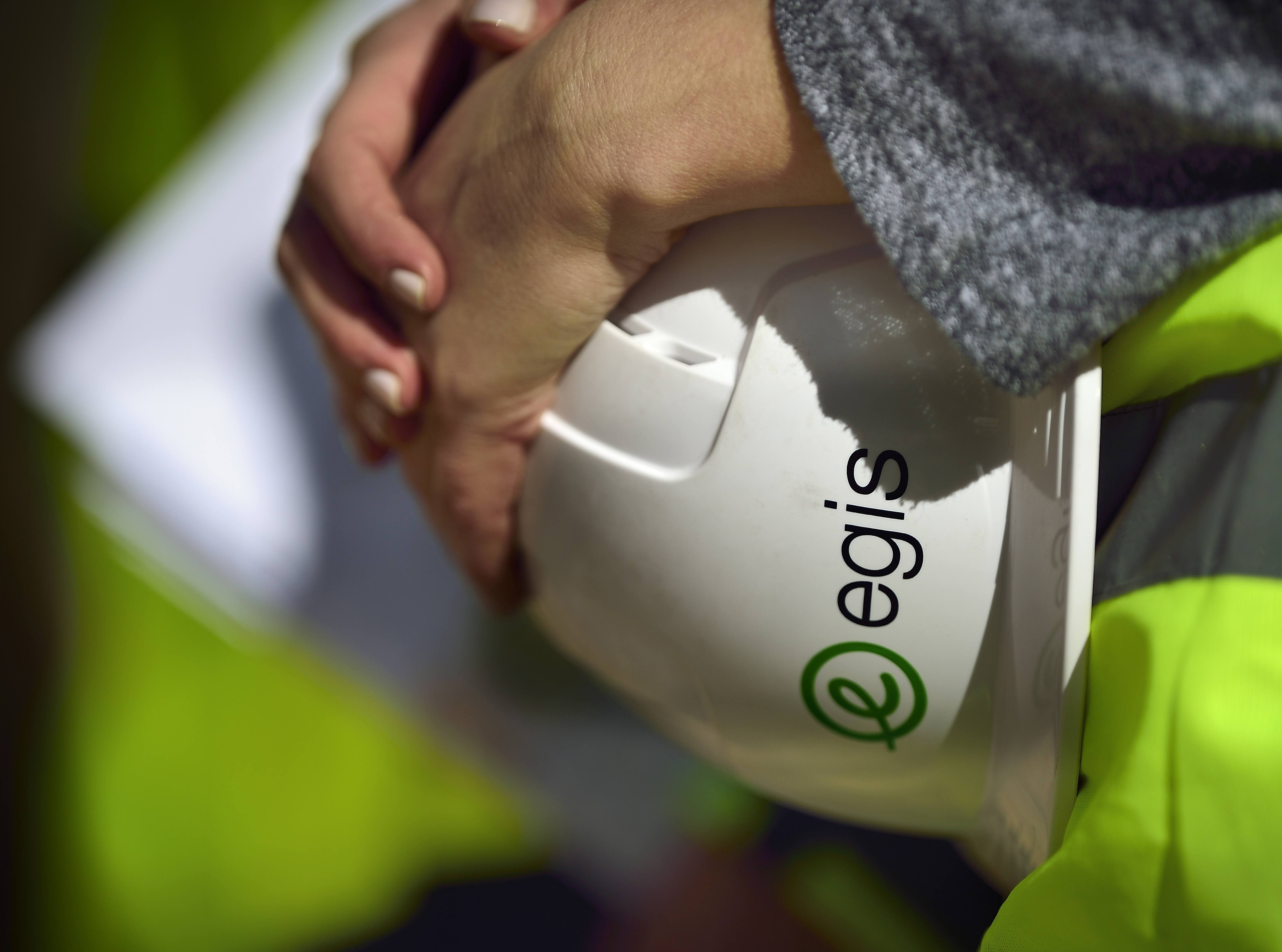 Man holding a white helmet with the EGIS logo