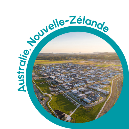 Image circulaire avec une bordure sarcelle montrant une vue panoramique d'une zone suburbaine en Australie ou en Nouvelle-Zélande. L'image montre un quartier résidentiel bien organisé avec des rangées de maisons, des pelouses vertes et des rues sinueuses. L'arrière-plan comprend des champs ouverts et des collines lointaines sous un ciel clair. Le texte « Australie . Nouvelle-Zélande » est écrit en bleu sarcelle et se courbe le long du bord supérieur gauche du cercle, indiquant le contexte de l'Australie et de la Nouvelle-Zélande.