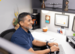 Man smiling at a desk, typing.