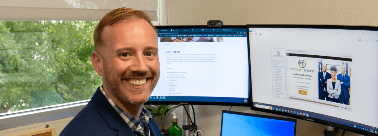 Westgate corporate employee smiling at his desk.
