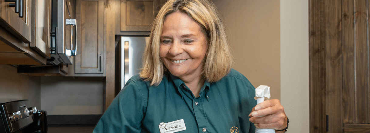 Westgate Housekeeping Team Member smiling at camera holding cleaning spray