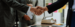 Hands shaking over a table