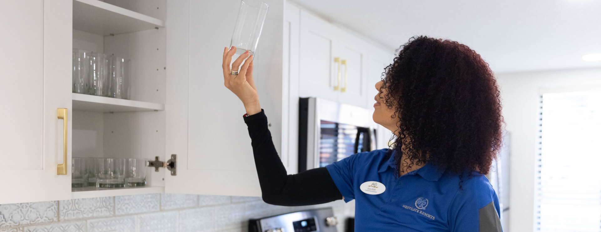 Westgate Resorts housekeeper holding up a clean glass 