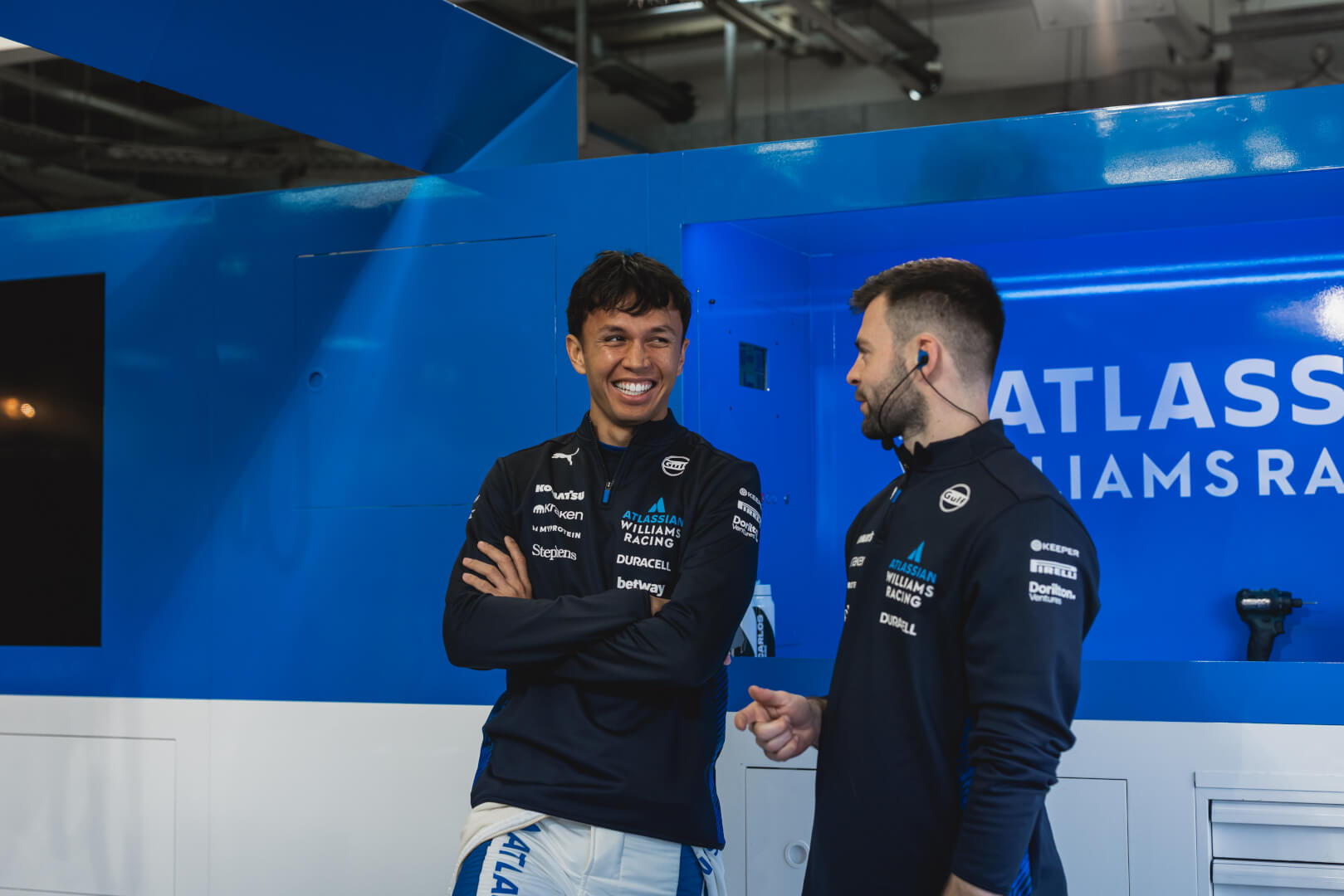 Two f1 engineers talking to each other