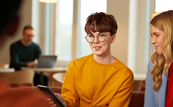 En kvinna med en iPad tillsammans med en kollega