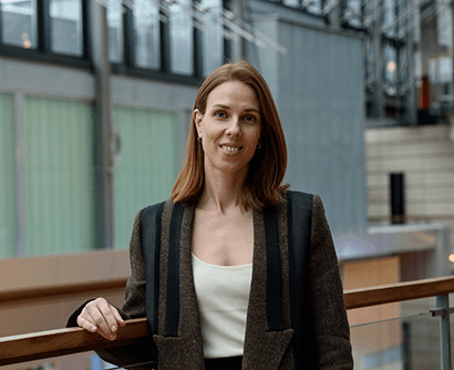A woman with brown hair, smiling to the camera