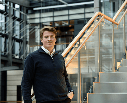 A man with brown hair, standing in a stairway