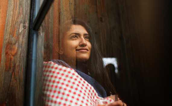 A woman with dark hair looking out of a window