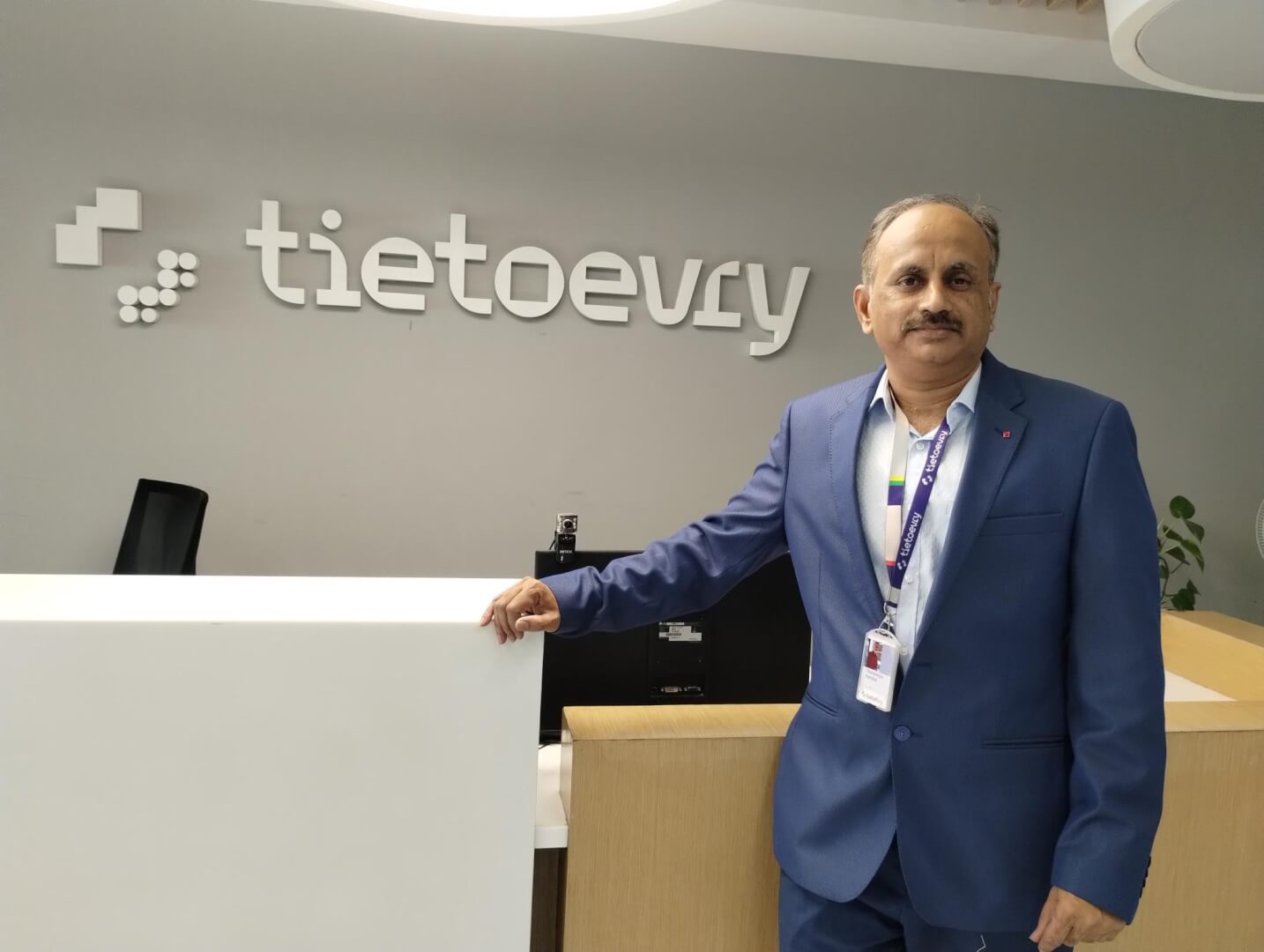 A man standing by a reception looking into the camera