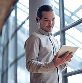 A man with brown hair looking at his tablet