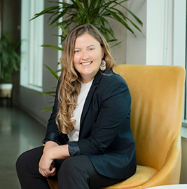 A woman sitting in a chair and smiling to the camera
