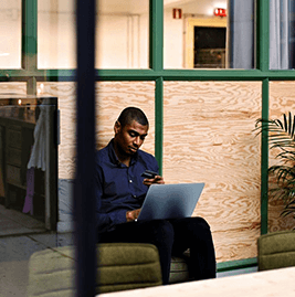 A man sitting by his computer with a payment card