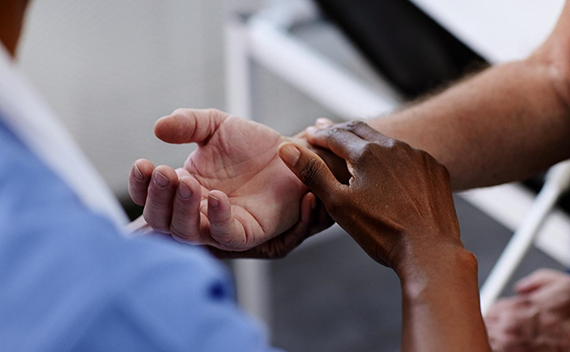 A doctor feeling the pulse of a patient