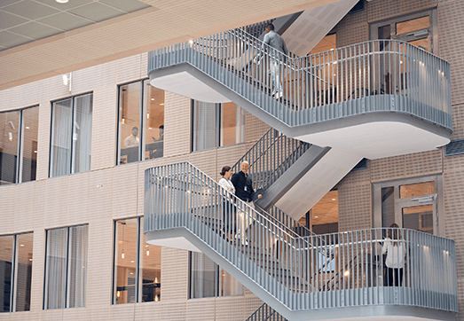 People walking in the stairs, talking to each other, in Tietoevrys' Stockholm office.
