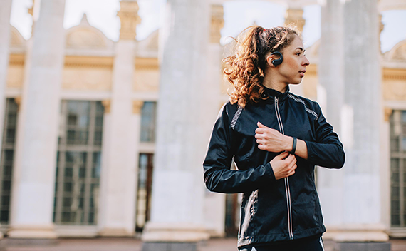A woman outside of a building in her running outfit