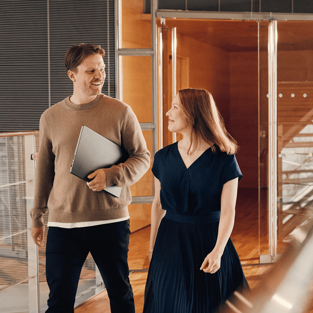 Two colleagues sitting on a stair, talking and laughing