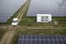 Blue collar workers talking infront of generator in combined energy park, service car on the side