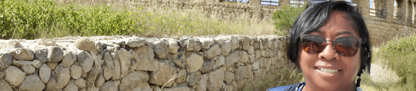 woman outside stone wall