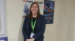Nikki standing in front of a poster at work