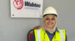 Shereen standing next to a wall with a Wabtec sign wearing a hard hat